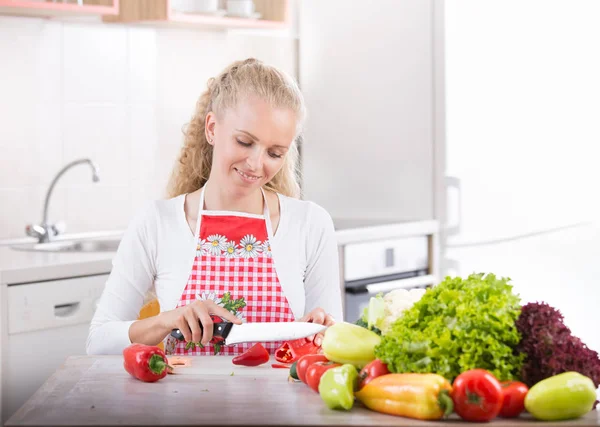 Mulher cortando vegetais na cozinha — Fotografia de Stock