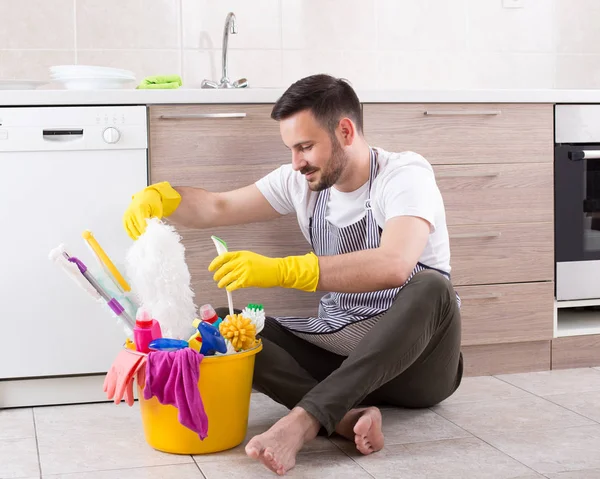 Homme avec des fournitures de nettoyage dans la cuisine — Photo