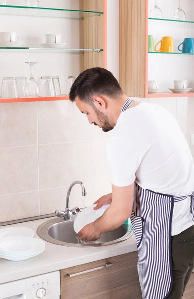 Человек моет посуду — стоковое фото