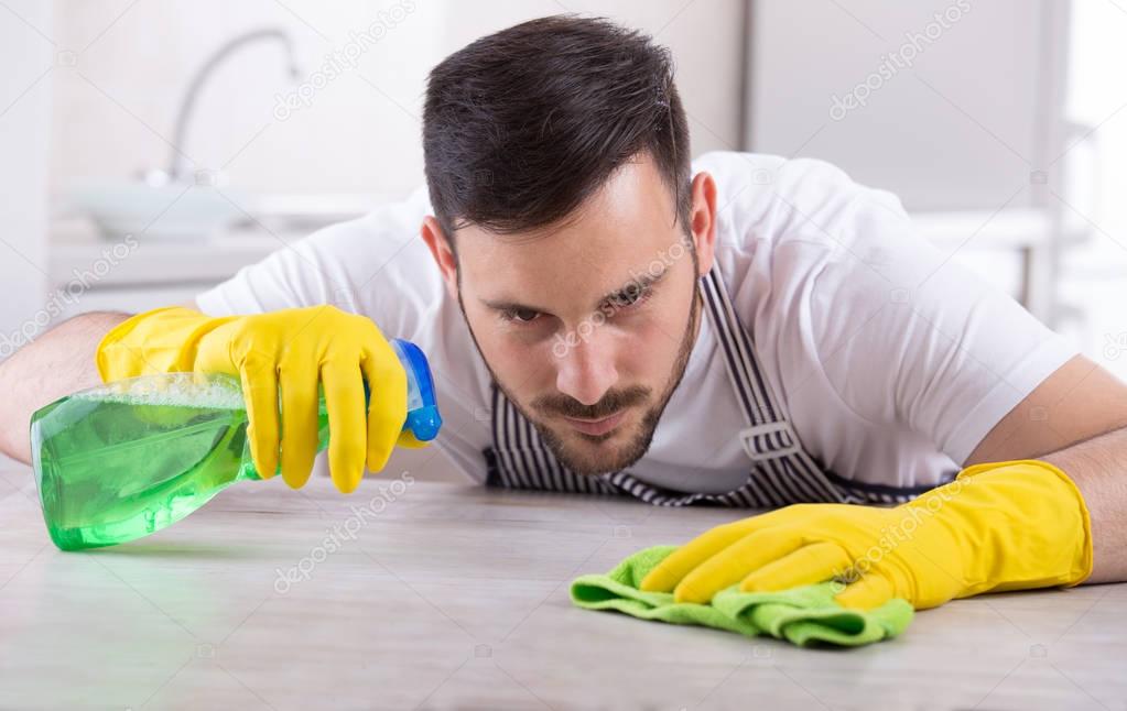 Man wiping kitchen table