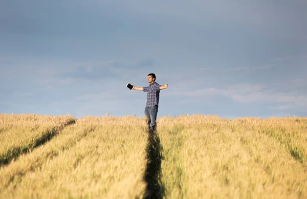 Man with outstretched arms in field — Stock Photo, Image