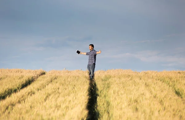 Mann mit ausgestreckten Armen im Feld — Stockfoto