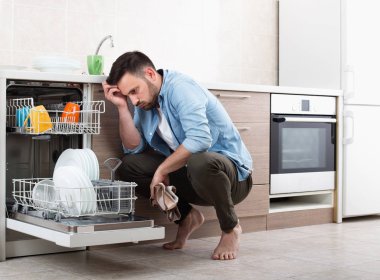 Açık bulaşık makinesi yanında yorgun adam