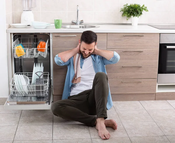 Tired man beside open dishwasher — Stock Photo, Image