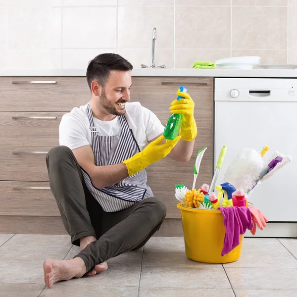 Homme avec des fournitures de nettoyage dans la cuisine — Photo