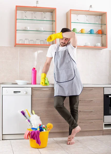 Moe man kijken reinigingsapparatuur in keuken — Stockfoto