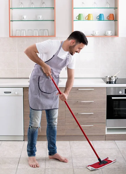 Homem esfregando chão na cozinha — Fotografia de Stock