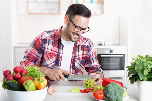 Mann hackt Gemüse in Küche — Stockfoto