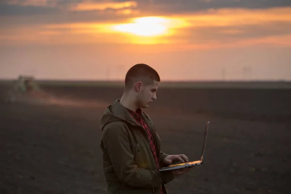 Bonde med laptop på fältet — Stockfoto