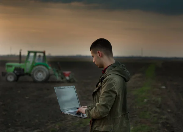 Agricultor con portátil delante del tractor — Foto de Stock