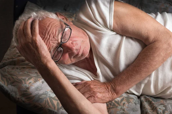 Yaşlı adam yatakta yatan — Stok fotoğraf