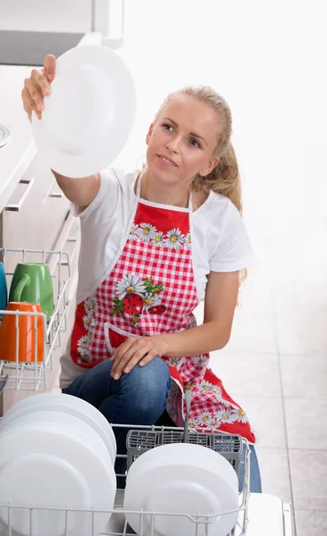 Woman holding plate above dishwasher — Stock Photo, Image