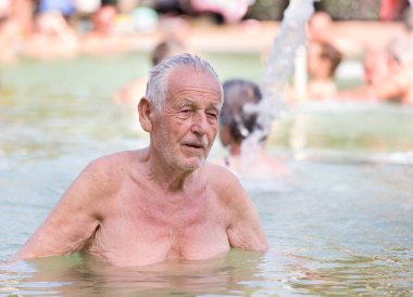 Yaşlı adam havuzda dinlenme