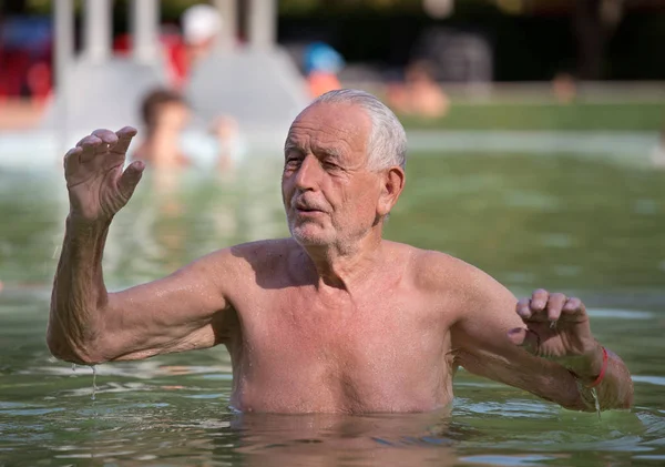 Viejo descansando en la piscina — Foto de Stock