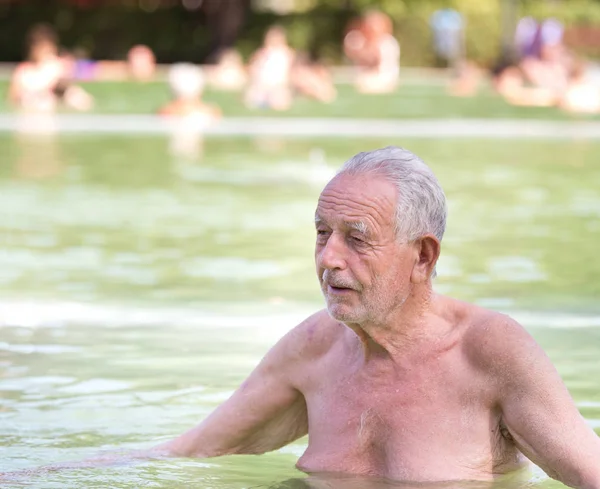 Yaşlı adam havuzda dinlenme