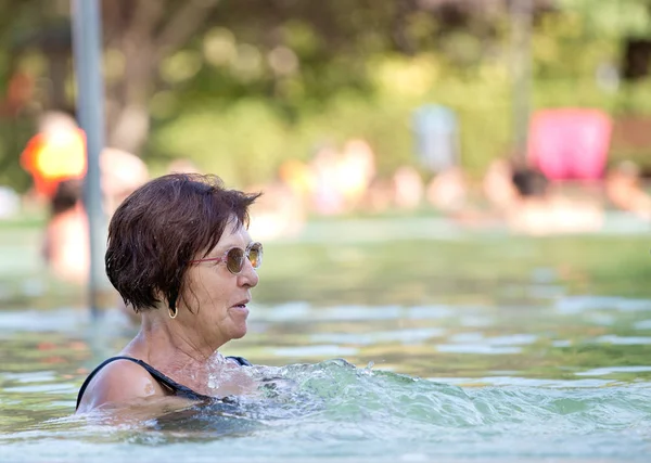 Velha mulher descansando na piscina — Fotografia de Stock