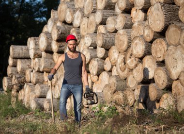 Oduncu chainsaw ve ormanda balta ile