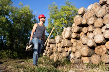 Oduncu chainsaw ve ormanda balta ile