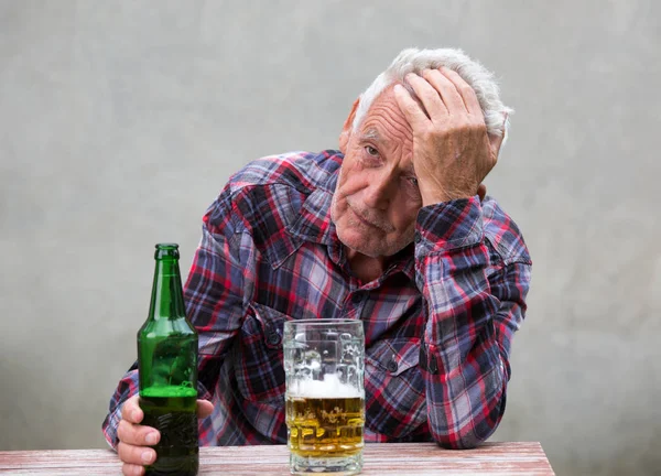 Hombre mayor con botella de cerveza y taza — Foto de Stock