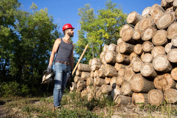 Oduncu chainsaw ve ormanda balta ile