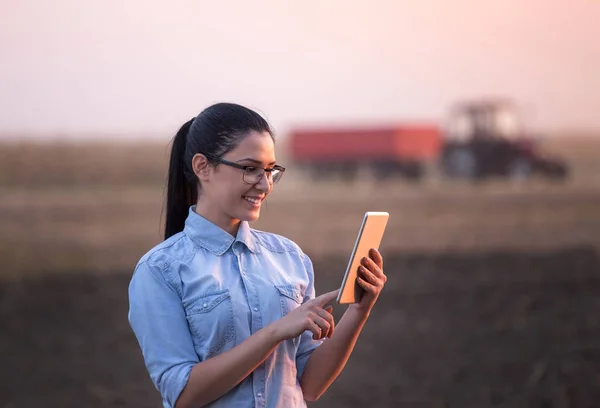 Femme agricultrice avec comprimé dans le champ — Photo