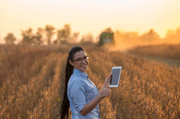 Chica agricultora con tableta y cosechadora — Foto de Stock