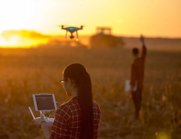 Frau steuert Drohne über Ackerland — Stockfoto