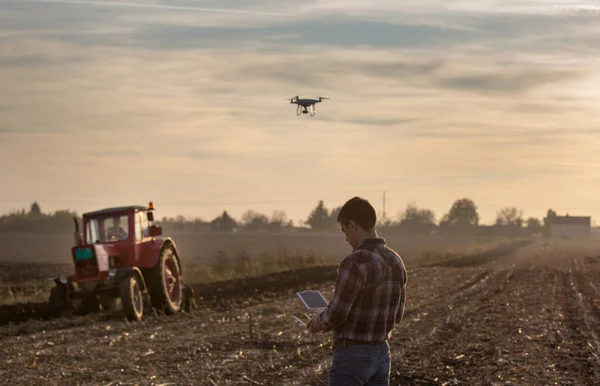 Farmer navigating drone above farmland