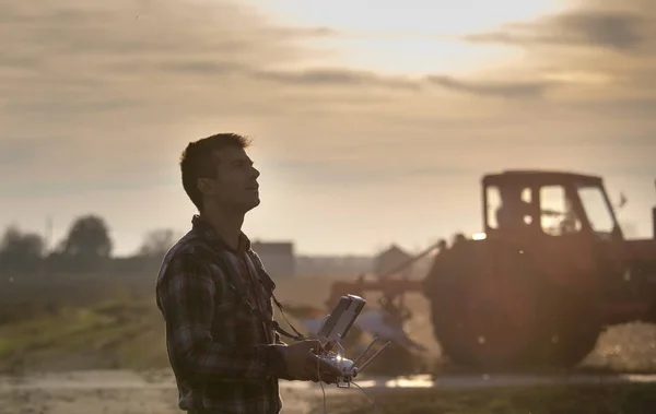 Agricultor navegando dron sobre tierras de cultivo —  Fotos de Stock