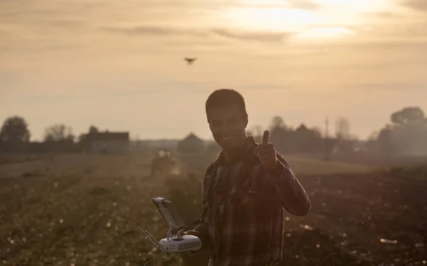 Boer navigeren drone boven landbouwgrond — Stockfoto