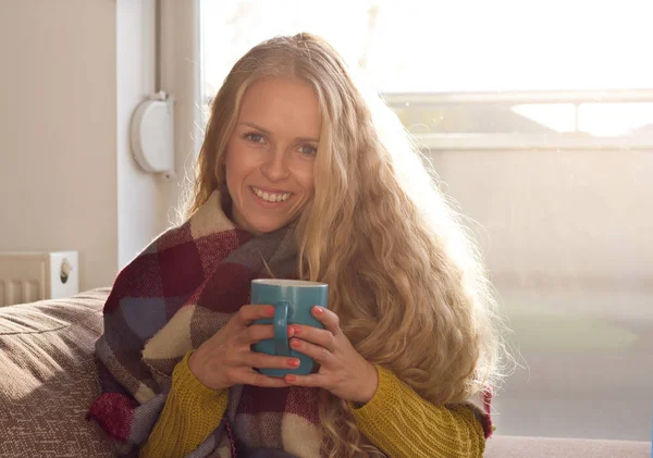 Mädchen trinkt Tee auf dem Sofa im Winter — Stockfoto