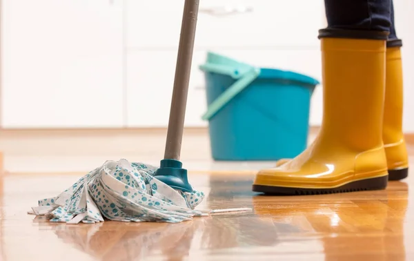 タイル張りの床を拭くことの家政婦 — ストック写真