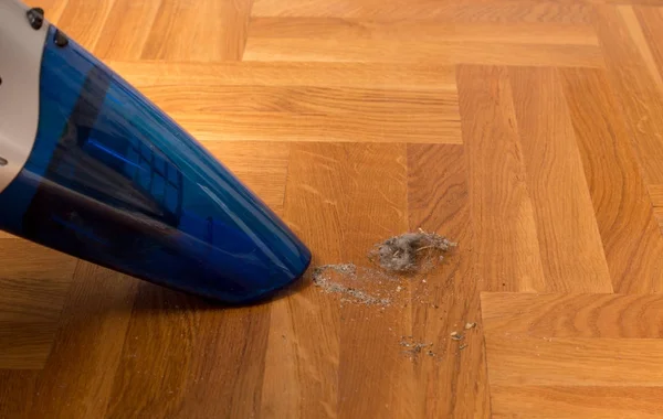 Staubsauger saugt Schmutz vom Boden — Stockfoto