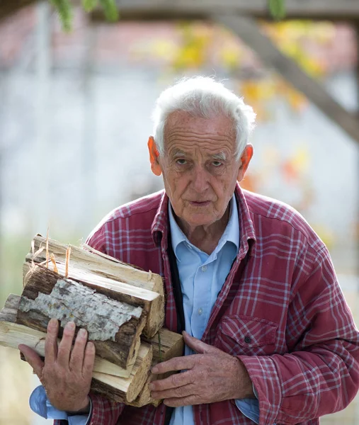 Oude man die vuur log — Stockfoto