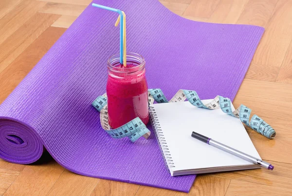 Cuaderno y batido en esterilla de yoga — Foto de Stock