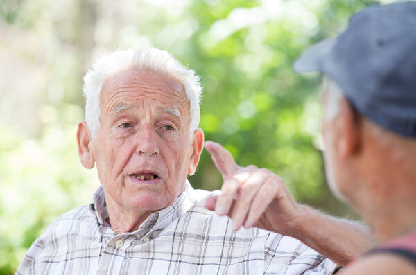 Two senior men talking in park