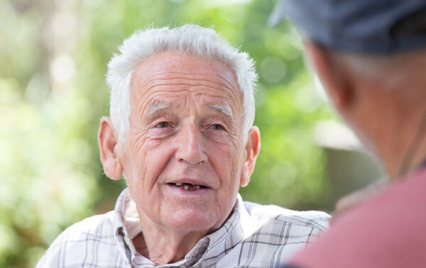 Two senior men talking in park