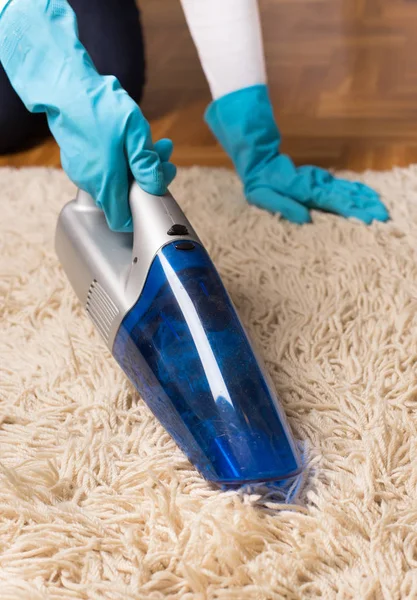 Person with gloves vacuuming carpet — Stock Photo, Image