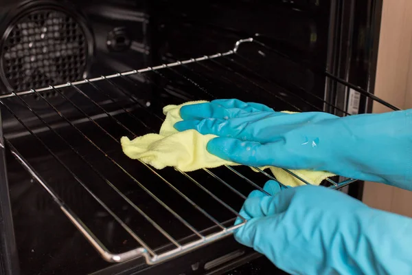 Manos con guantes limpiando el alambre del horno —  Fotos de Stock