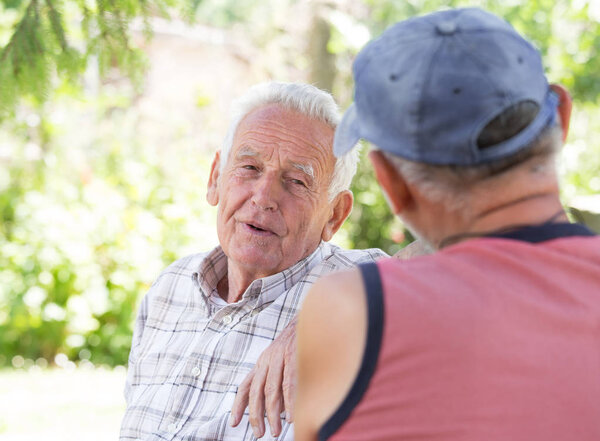 Two senior men talking in park