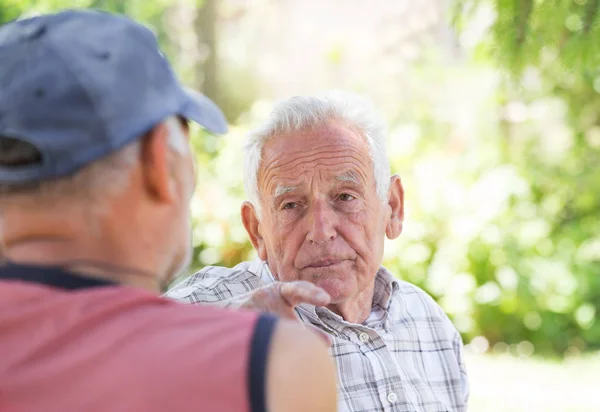 Zwei Senioren unterhalten sich im Park — Stockfoto