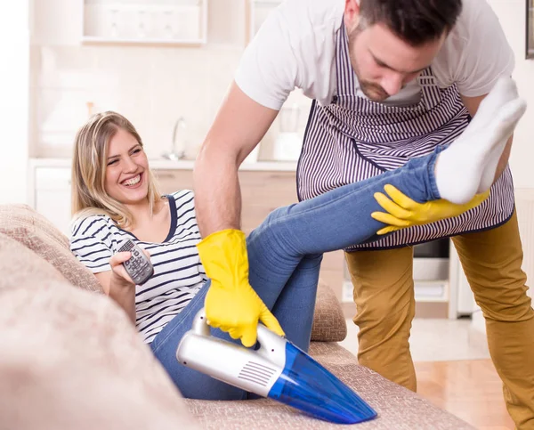 Husband doing housework while wife resting — Stock Photo, Image