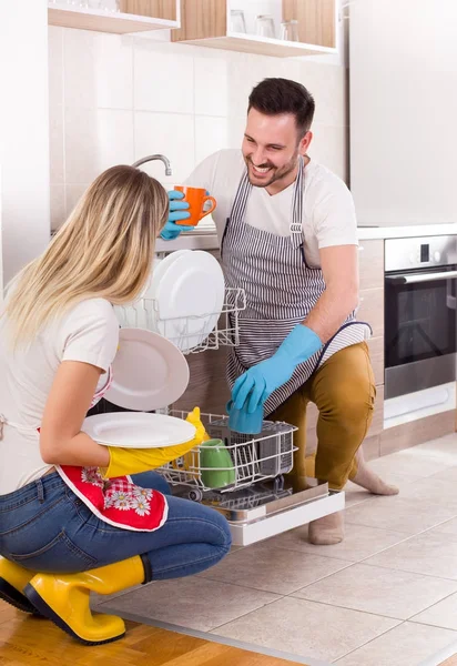 Coppia felice scarico lavastoviglie — Foto Stock