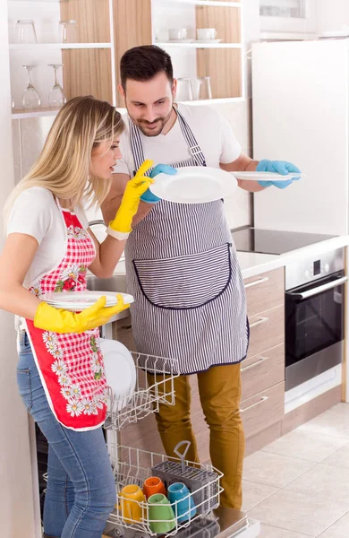 Pareja con platos limpios de lavavajillas — Foto de Stock