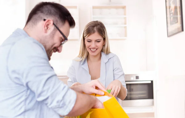 Young couple with shopping bags at home — Stock Photo, Image