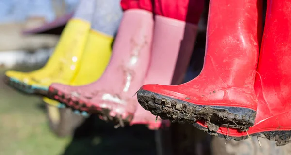 Three girls in dirty gumboots — Stock Photo, Image