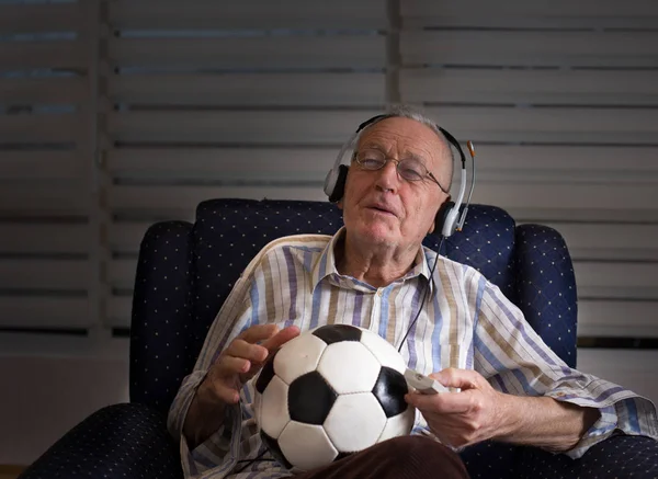 Vieil homme avec ballon de football regarder la télévision — Photo