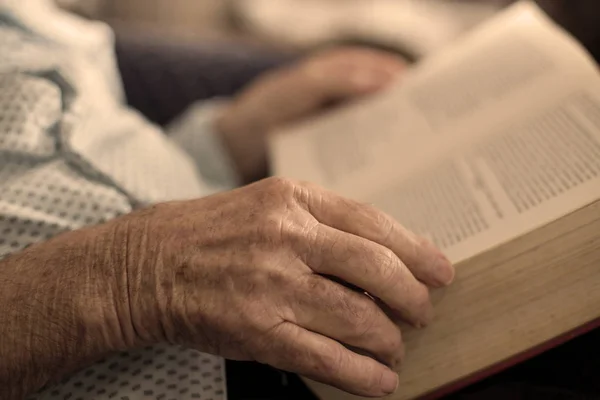 Stary człowiek czytania książki. Zbliżenie na pomarszczone dłonie — Zdjęcie stockowe
