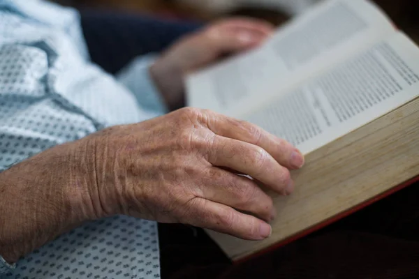 Gammal man läsebok. Närbild av rynkiga händer — Stockfoto