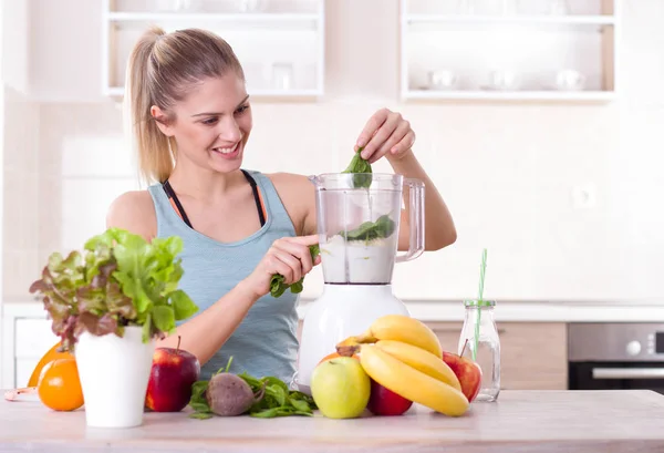 Flickan förbereder smoothie i köket — Stockfoto